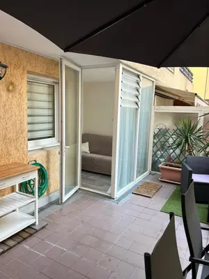 a patio with a couch and a table and chairs at Studio Centre Ville in Nice