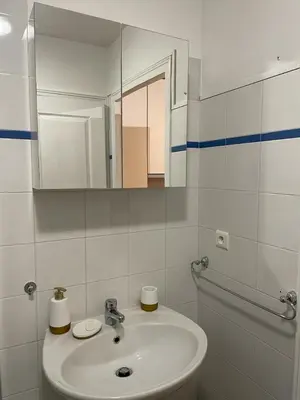 a white bathroom with a sink and a mirror at Studio Centre Ville in Nice