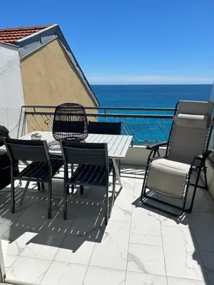 a table and chairs on a balcony with the ocean at Le Grand Bleu in Nice