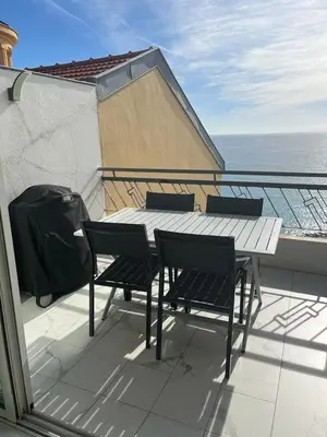 a table and chairs on a balcony with the ocean at Le Grand Bleu in Nice