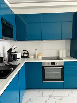 a blue kitchen with a stove and blue cabinets at Le Grand Bleu in Nice