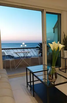 a living room with a table and a view of the ocean at Nice Promenade des Anglais Vue Mer in Nice