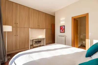 a bedroom with a large white bed and wooden cabinets at Market Square 2 bedrooms 2 baths AC private garage in Beaulieu-sur-Mer