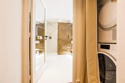 a bathroom with a washing machine and a mirror at LE MAY AP4338 By Riviera Holiday Homes in Villefranche-sur-Mer