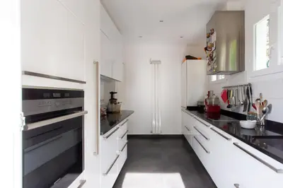 a kitchen with white cabinets and black counter tops at Beautiful villa with panoramic view over Nice in Nice