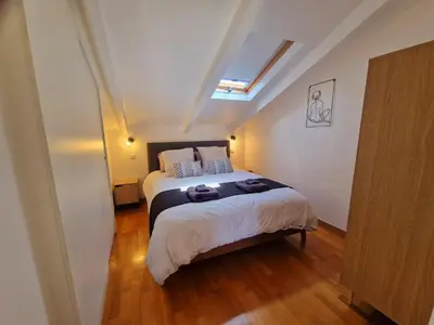 a bedroom with a bed and a skylight at Le Michelangelo - Place Masséna in Nice