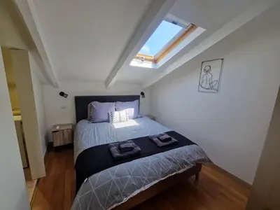 a bedroom with a bed and a skylight at Le Michelangelo - Place Masséna in Nice