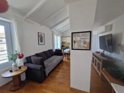 a living room with a couch and a tv at Le Michelangelo - Place Masséna in Nice