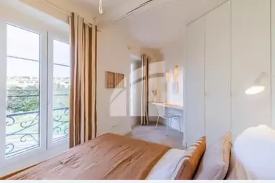 a bedroom with a bed and a large window at 2 pièces vieux Nice vue coulée verte in Nice