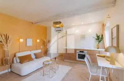 a living room with a white couch and a table at 2 pièces vieux Nice vue coulée verte in Nice