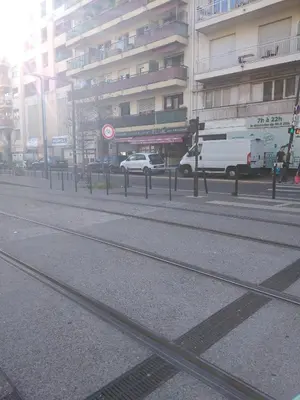 a street with train tracks in front of a building at Elegant F1 proche tramway et plage in Nice