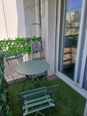 a table and a chair sitting on a balcony at Elegant F1 proche tramway et plage in Nice