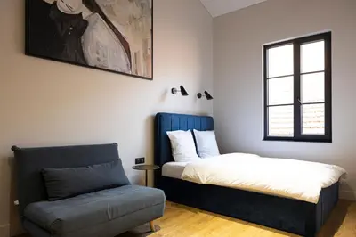 a bedroom with a bed and a chair and a window at Centrum Nice in Nice