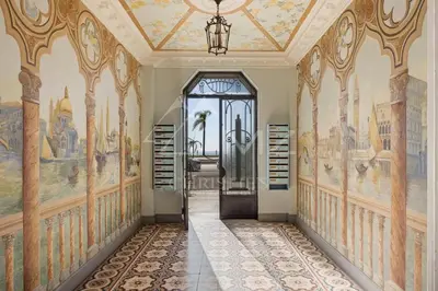 a hallway with paintings on the walls and a door at Luxury apartment with sea view on the first line Promenade des Anglais in Nice