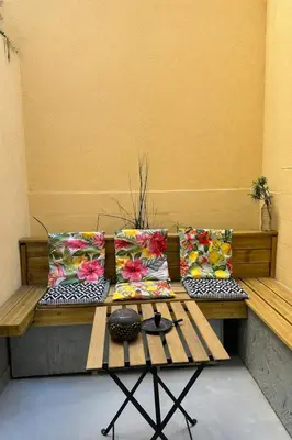 a bench with four pillows on it with a table at Studio 