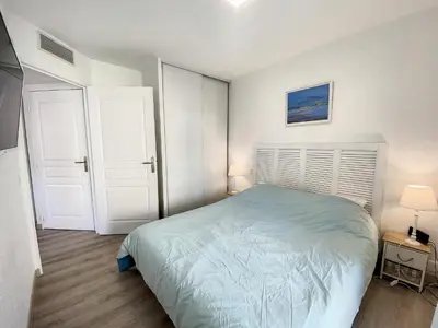 a bedroom with a bed and two white doors at A303- Appartement 3 pieces 4 personnes- Le Crystal in Cagnes-sur-Mer