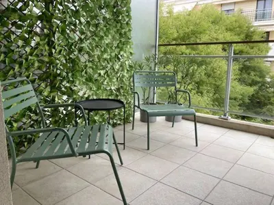 two green chairs and a table on a balcony at A303- Appartement 3 pieces 4 personnes- Le Crystal in Cagnes-sur-Mer
