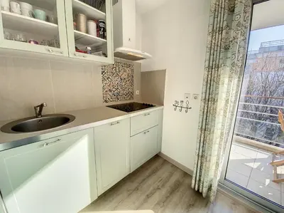 a kitchen with white cabinets and a sink and a window at A303- Appartement 3 pieces 4 personnes- Le Crystal in Cagnes-sur-Mer