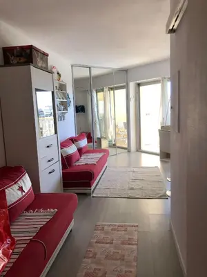 a living room with two red couches and a mirror at Charmant studio à Cros de Cagnes in Cagnes-sur-Mer