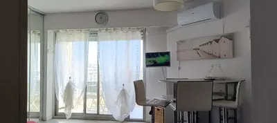 a room with a desk and a large window at Charmant studio à Cros de Cagnes in Cagnes-sur-Mer