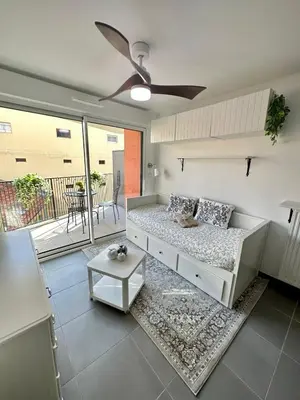 a living room with a bed and a ceiling fan at Charmant Studio à proximité du Port de Nice in Nice