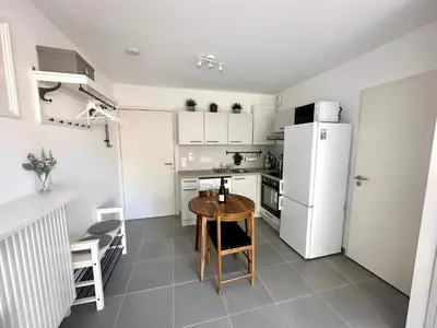 a kitchen with a table and a white refrigerator at Charmant Studio à proximité du Port de Nice in Nice