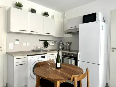 a kitchen with a wooden table with wine glasses on it at Charmant Studio à proximité du Port de Nice in Nice