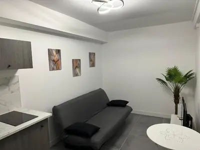 a living room with a black couch and a table at Apart Nissa Bella Seafont / Promenade des Anglais in Nice
