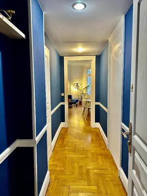 a hallway with blue walls and a wooden floor at Negresco Residence Apartment with AC Promenade des Anglais in Nice