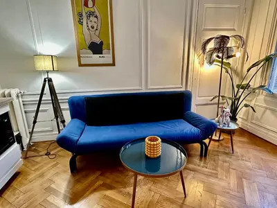 a living room with a blue couch and a table at Negresco Residence Apartment with AC Promenade des Anglais in Nice