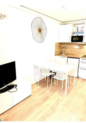 a white kitchen with a white table and chairs at Residence Californie in Nice