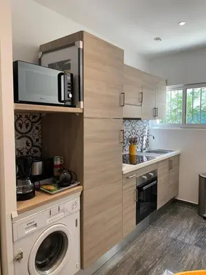 a kitchen with a washing machine and a microwave at Nice Proche mer Climatisé 2 pièces style loft in Nice
