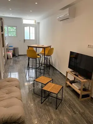 a living room with two tables and a flat screen tv at Nice Proche mer Climatisé 2 pièces style loft in Nice