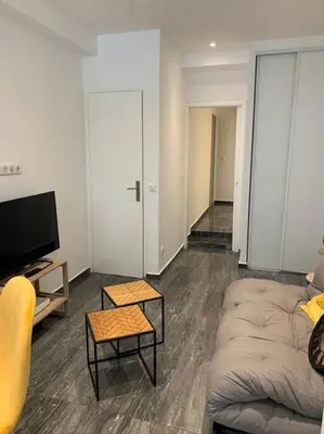 a living room with a couch and a tv at Nice Proche mer Climatisé 2 pièces style loft in Nice
