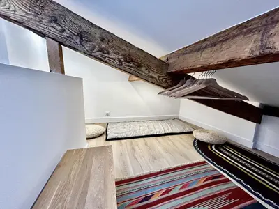 an attic room with wooden beams and rug at Nice Chateau Duplex Menica vue sur le vieux Nice in Nice
