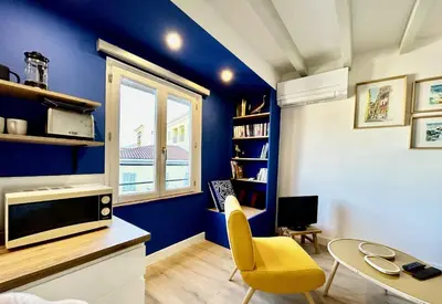 a living room with blue walls and a yellow chair at Nice Chateau Duplex Menica vue sur le vieux Nice in Nice