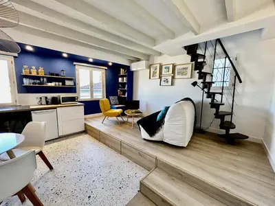a living room with blue walls and a spiral staircase at Nice Chateau Duplex Menica vue sur le vieux Nice in Nice