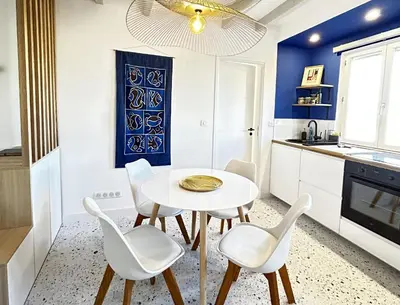 a white dining room with a white table and chairs at Nice Chateau Duplex Menica vue sur le vieux Nice in Nice