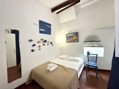 a bedroom with a bed and a blue chair at ApartHotel Riviera - BARILLERIE 3 - Vieille Ville 50m de la plage- 4 pieces - AC in Nice