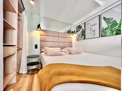 a bedroom with a large bed with a large headboard at DUPLEX LE GESÙ - VIEILLE VILLE - CLIM - WIFI in Nice