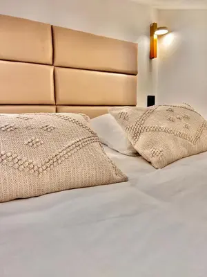 a bed with white sheets and pillows on it at DUPLEX LE GESÙ - VIEILLE VILLE - CLIM - WIFI in Nice