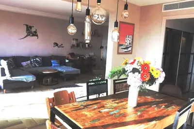a living room with a table with flowers on it at Appartement Nice CENTRE vue Mer avec piscine pour FAMILLE, couple d'amis pas de groupes de jeunes autorisés in Nice