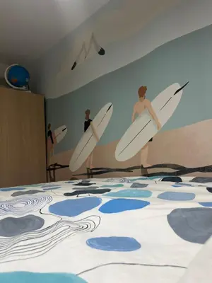 a room with three surfers holding surfboards on a wall at Appartement Nice CENTRE vue Mer avec piscine pour FAMILLE, couple d'amis pas de groupes de jeunes autorisés in Nice