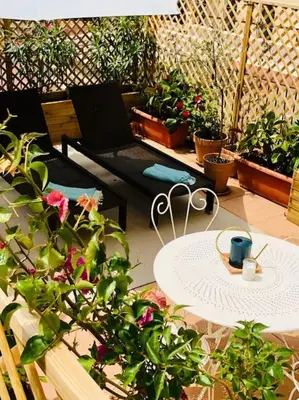 a patio with a table and chairs and potted plants at Charming studio mezzanine w/ large terrace - Nice in Nice