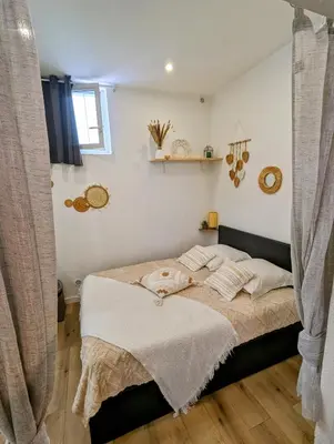 a bedroom with a bed with white sheets and a window at Appartement cosy proche du port in Nice