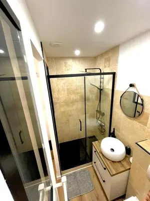 a bathroom with a glass shower and a sink at Appartement cosy proche du port in Nice