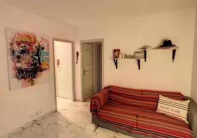 a living room with a couch in a room at Superbe Studio tout équipé/Proche mer et commodité in Saint-Laurent-du-Var