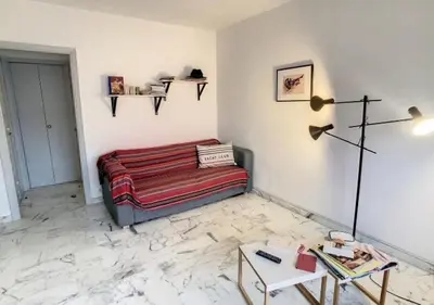 a living room with a couch and a table at Superbe Studio tout équipé/Proche mer et commodité in Saint-Laurent-du-Var