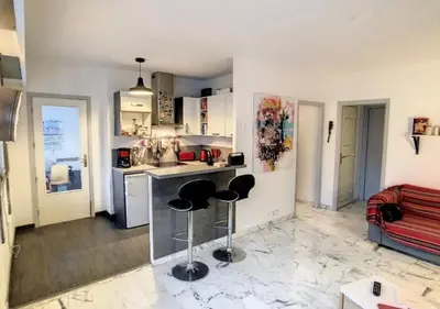 a kitchen with two bar stools in a room at Superbe Studio tout équipé/Proche mer et commodité in Saint-Laurent-du-Var