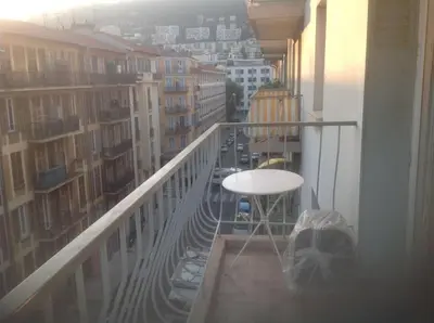 a balcony with a table and a view of a city at Appartamento zona porto a 10 mn a piedi dal mare in Nice